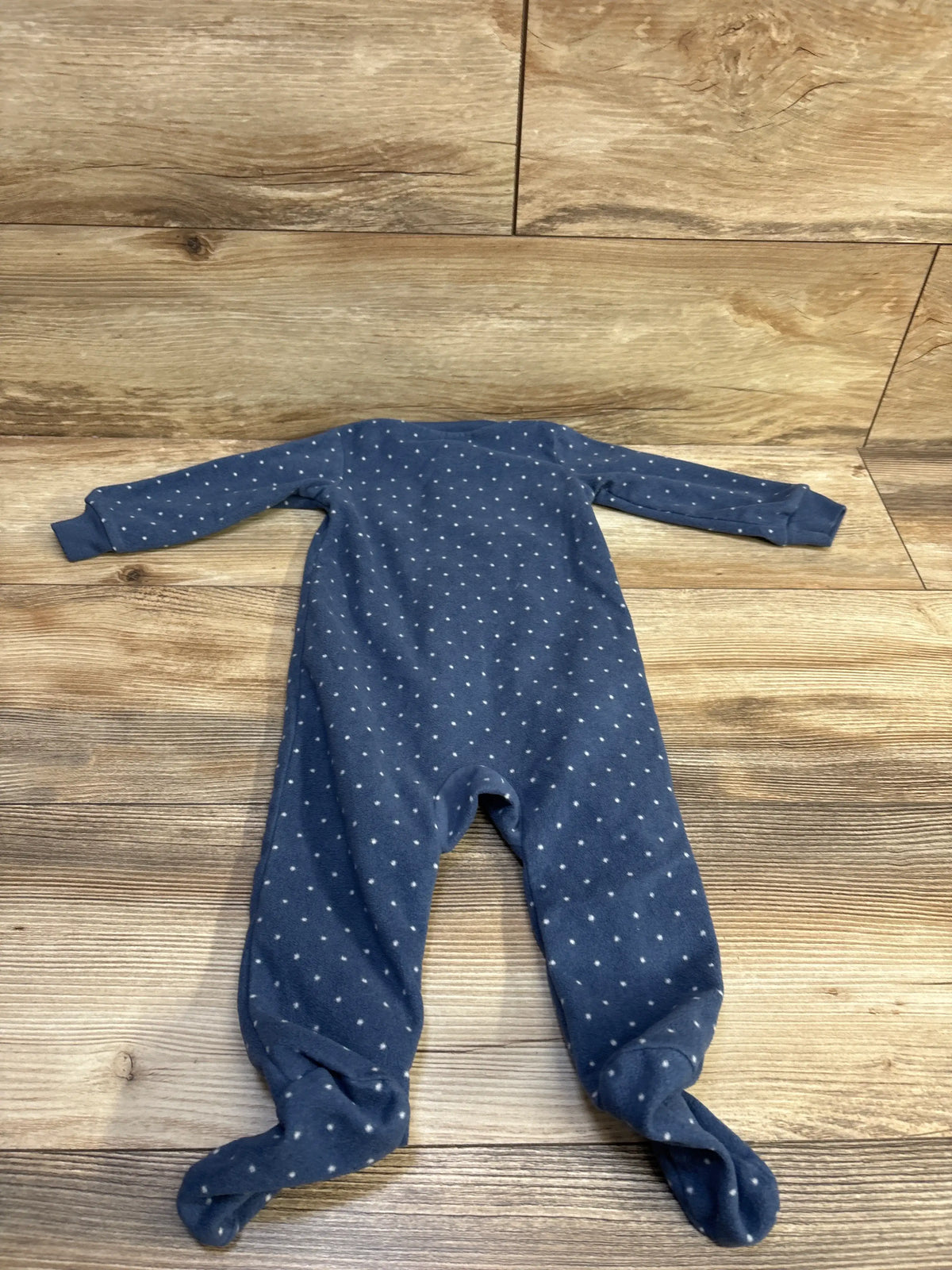 Blue Carter's blanket sleeper with white polka dots for 9 month old baby on wood background
