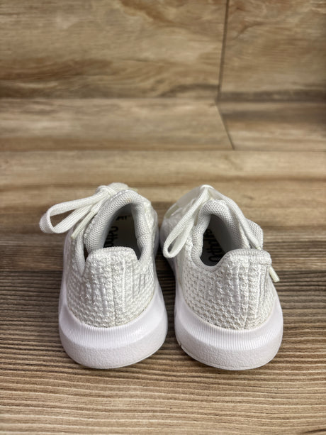 Rear view of Adidas Swift Run 1.0 sneakers showcasing white textured knit uppers, laces, and soles on a wood floor