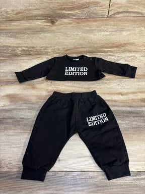 Flat lay of black 2 piece crop top and joggers showing white LIMITED EDITION text on chest and left thigh on wood background