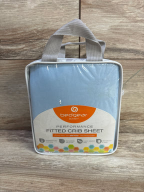 Front of packaged Bedgear Baby Dri-Tec fitted crib sheet in light blue with label and handle on wood background