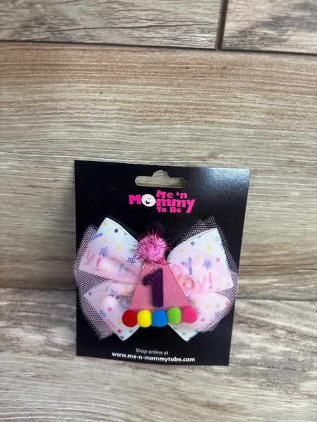 Front view of 1st birthday hair bow with pink glitter party hat number 1, pastel bow and tulle with colorful pom poms on black card