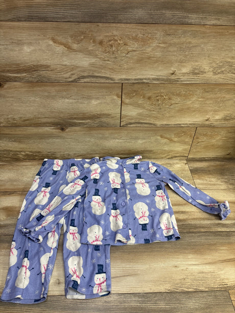 Flat lay of purple coat-style snowman pajama set with button-front top and matching pants on wood
