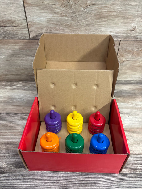 Lakeshore Learn & Play Color Rings Sorting Board showcasing six colored ring stacks in a cardboard tray on a wood floor