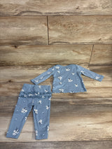 Flat lay of Carter's blue 2-piece baby set, long-sleeve floral shirt and leggings with ruffle detail on wood plank background