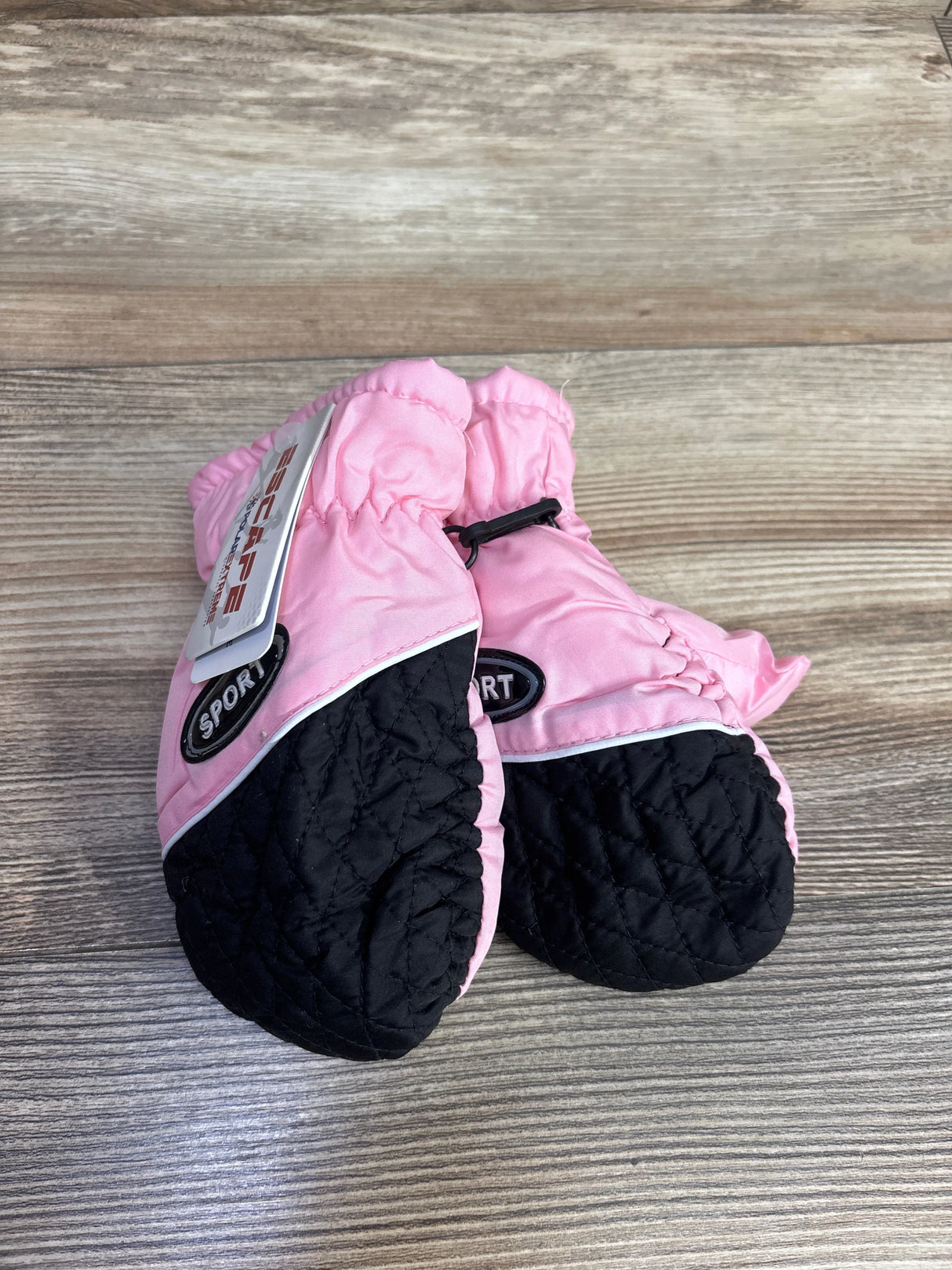 Pink and black toddler mittens with sport label on wood background at kids resale store