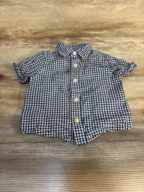 Baby boy short sleeve blue checkered shirt with buttons on wood surface