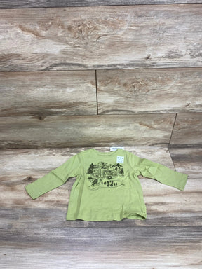 Flat lay of Old Navy toddler long-sleeve green shirt showcasing camper van lets roll graphic on wood floor background