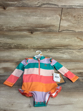 Top-down view of girls' one-piece rashguard swimsuit by Eddie Bauer with wide colorful stripes and front zipper on wood floor
