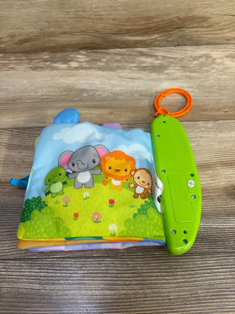Top view of Vtech Peek & Play baby cloth book with animal characters and attached green sound module with orange clip on wood