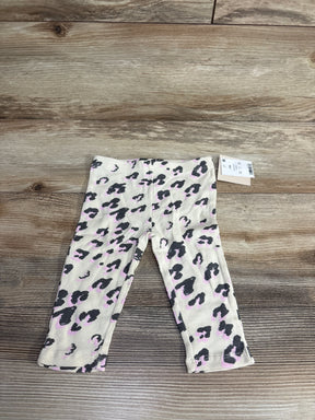 Baby girl leopard print pants with pink and black pattern on wood background