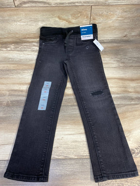 Black Old Navy skinny jeans for kids with elastic waist and toddler size tag, on wood floor