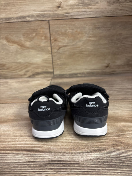 Rear view of New Balance 515 Hook and Loop Sneakers showcasing black uppers and white midsoles on a wood floor