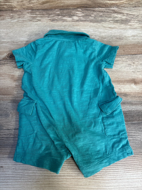 Teal short sleeve baby romper with pockets on wood background, children's clothing