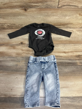 Baby outfit with black Guns N' Roses onesie and acid-wash jeans on wood floor