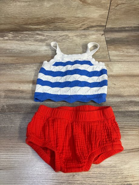 Flat lay of 2-piece 4th of July set: blue-and-white knit tank with scalloped hem and red crinkled bloomers on wood floor