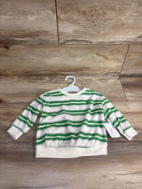 Kids white and green striped long sleeve sweater with palm tree embroidery, on plastic hanger over wooden background
