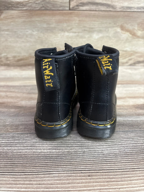 Rear view of Dr. Martens Black Softy boots, size 9C, showcasing yellow stitching and heel pull tabs on a wood-grain surface
