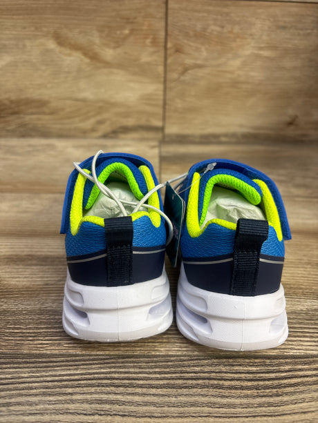 Rear view of blue Skechers S-Lights Glide-Step light-up sneakers showcasing neon green lining and white soles on a wood surface