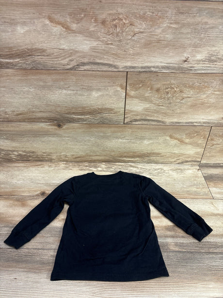 Back view of Carter’s Full Of Treats shirt in black, size 2T, with long sleeves on a wood-look background