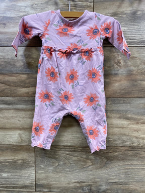 Pink baby romper with orange sunflower print hanging on wooden background