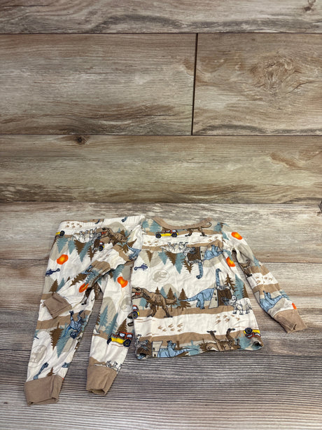 Overhead view of Jurassic World beige viscose pajama top showcasing dinosaur print and ribbed cuffs on a wood-grain background