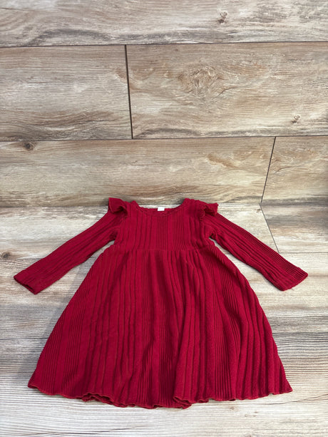 Flat lay of red ribbed long-sleeve toddler dress size 3T showcasing ruffled shoulder detail and gathered skirt with light wood background