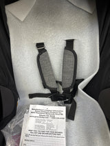 New infant car seat with gray safety harness and registration card in packaging