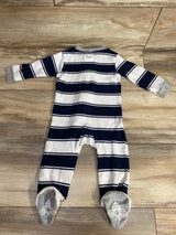 Navy and white striped baby footed sleeper with gray cuffs and bee logo on feet, laid flat on wooden floor