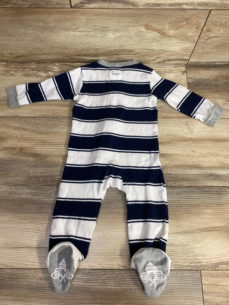 Navy and white striped baby footed sleeper with gray cuffs and bee logo on feet, laid flat on wooden floor