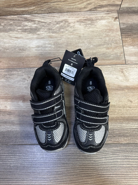 Top-down view of Athletic Works toddler two-strap black sneakers showing two Velcro straps, gray mesh panels, and attached hang tag on wood floor