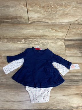 Navy blue long-sleeve baby dress with white polka dot bodysuit on wooden floor