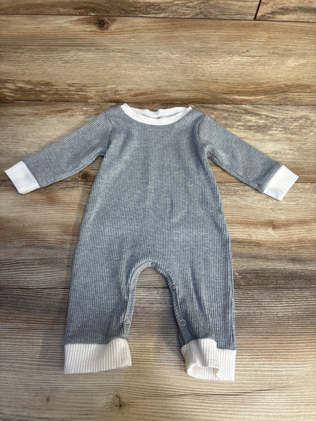 Gray ribbed baby romper with white cuffs and snap legs on wood background