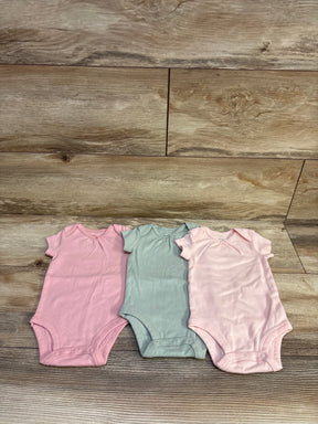 Front view of Carter’s three-pack bodysuits, size 3m, in pink, green, and pale pink with snap closures on wood
