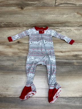 Flat-lay of Burt's Bees Baby grey footed sleeper showcasing polar bear Fair Isle print, red trim, front zipper, and non-slip sole grips on wood background