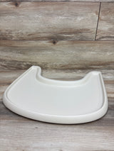 Close-up of the Stokke Tripp Trapp high chair tray showcasing its white molded surface on a wood-look floor
