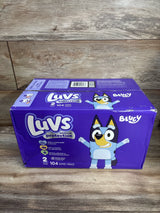 Front view of Luvs Platinum Protection Size 2 diaper box (104 count) showing Bluey character and branding on wooden tabletop
