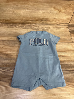 Flat lay of blue Ralph Lauren shortie romper showing POLO embroidered chest logo and snap neck on wood floor