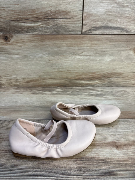 Light pink toddler ballet flats with elastic straps on wood floor
