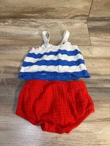 Top-down view of girls' 2-piece 4th of July set showcasing blue-and-white striped knit tank and red textured bloomer shorts on wood floor