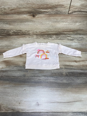 Front view of newborn pink Cat and Jack sweatshirt showcasing rainbow graphic and ruffle shoulder detail on wood background