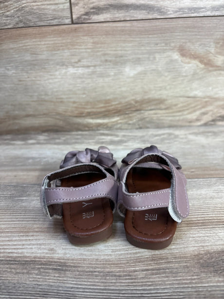 Rear view of EYY sandals in mauve showcasing velcro ankle straps and decorative bows on a light wood floor