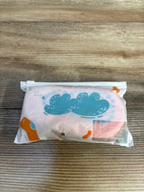 Pink baby socks with blue cloud design in clear packaging on wooden surface