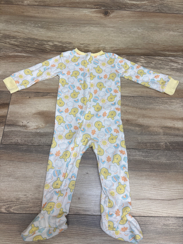 Front view of Disney Baby Winnie the Pooh sleeper showcasing footed legs and front zipper on a wood-grain surface