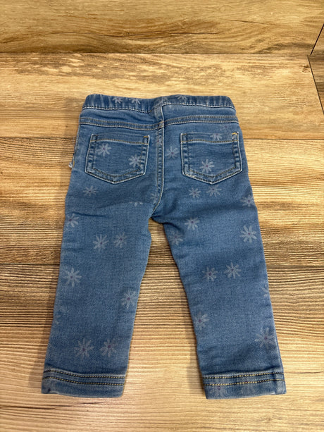 Back view of Cat & Jack blue jeggings for size 12 months showcasing floral pattern and two back pockets on a wooden surface