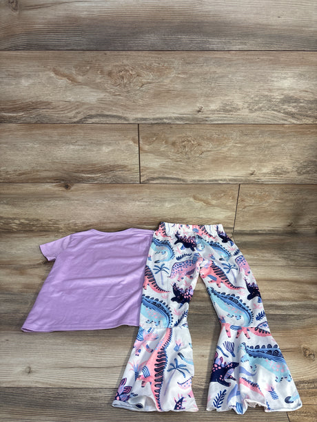 Flat lay of purple short-sleeve shirt and white flare pants with pastel dinosaur print and ruffled cuffs on wood floor