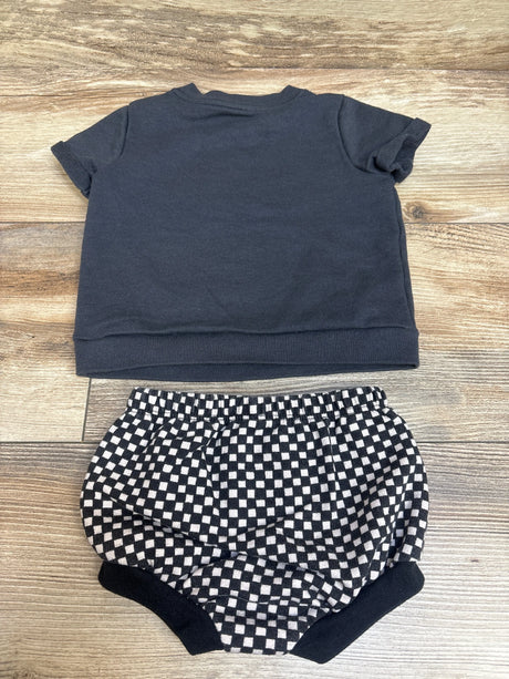 Top view of Cat & Jack two-piece shirt and bloomers set showing a dark gray shirt and checkerboard bloomers on a wood surface