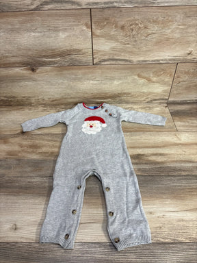 Gray baby onesie with Santa graphic, long sleeves, and snap buttons on wood floor