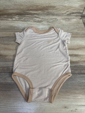 Neutral striped baby bodysuit with short sleeves and tan trim on wood background