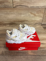 Three-quarter view of toddler Nike Huarache TD white sneakers size 2C showing mesh upper and heel cage on red Nike box