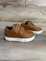 Brown toddler shoes with velcro straps, navy lining, white soles on wood floor